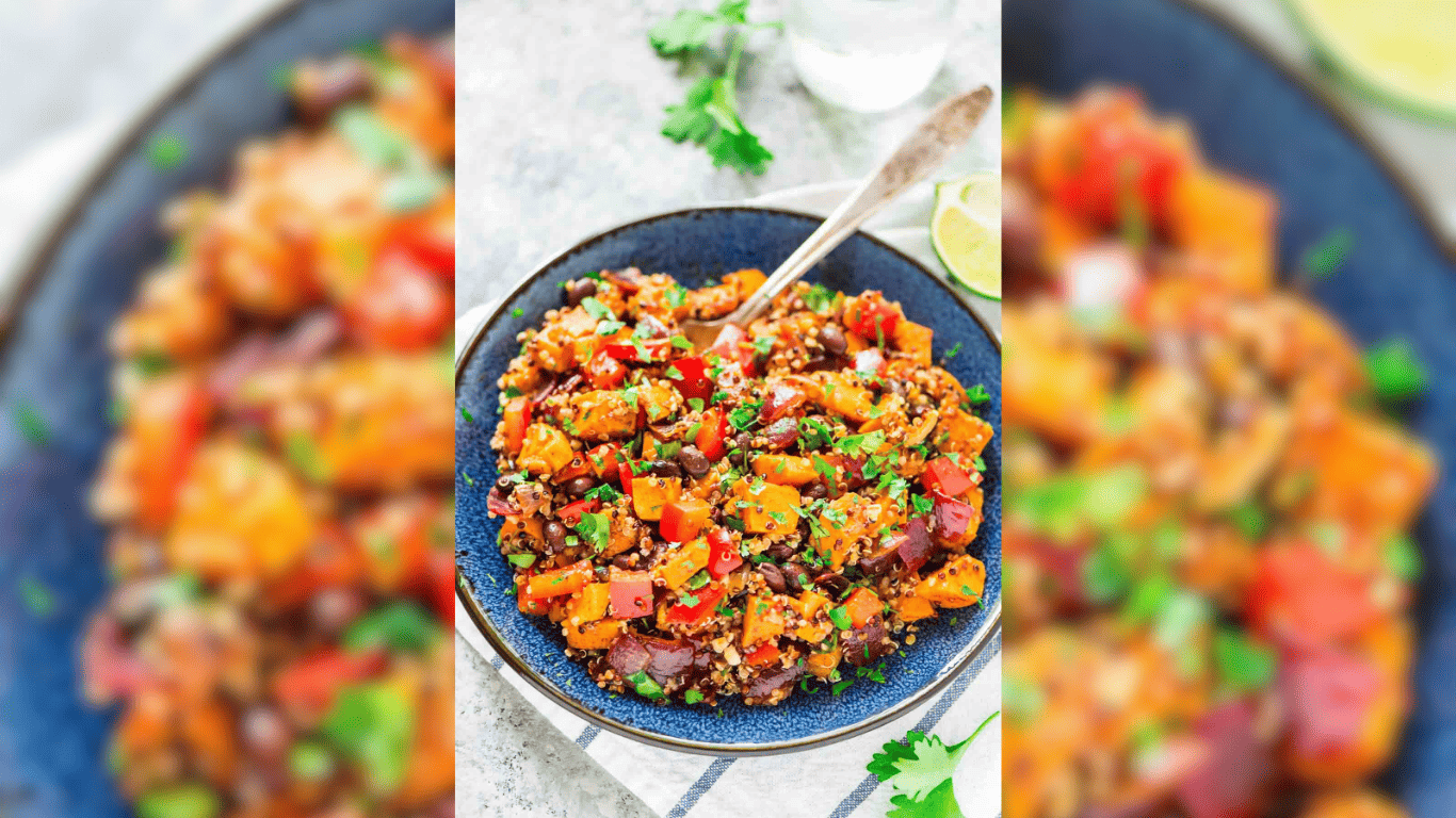 Colorful veggie salad with quinoa, beans, sweet potatoes, and peppers in a blue bowl