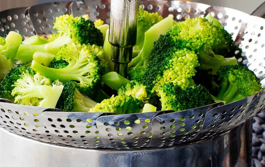 Steamed broccoli in a metal basket