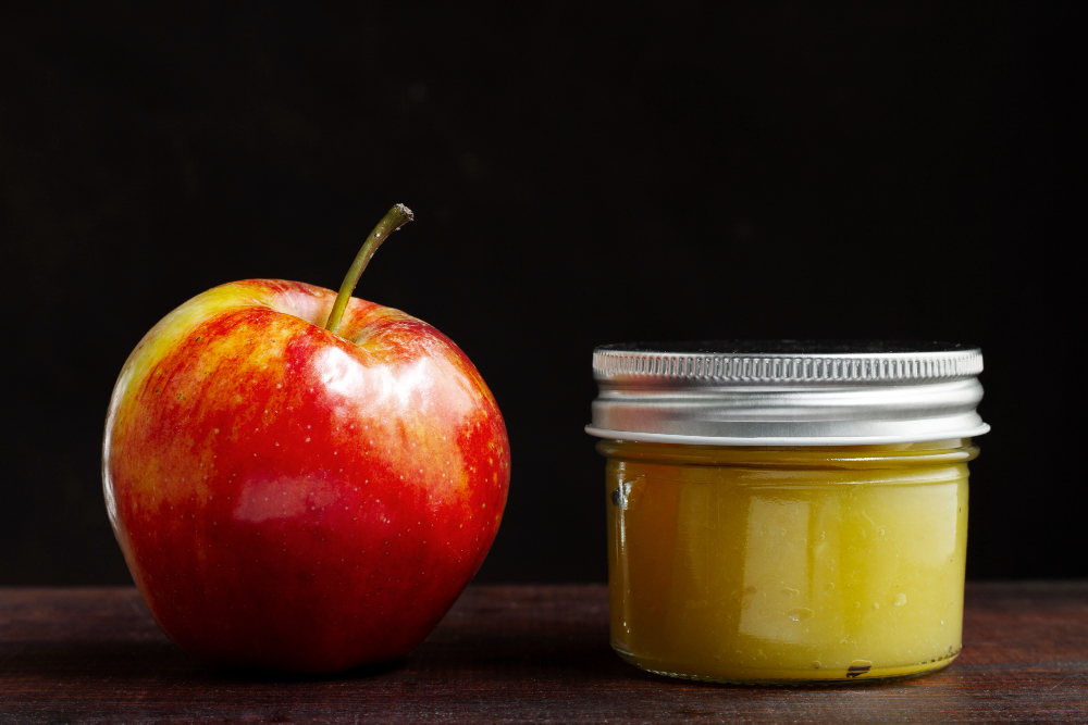 Red apple with apple puree in the jar