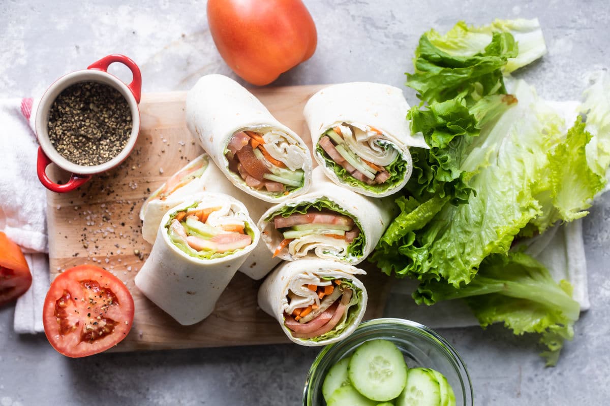 Veggie and ham tortilla wraps with lettuce, tomato, cucumber, and carrot